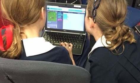 Two students working on a laptop