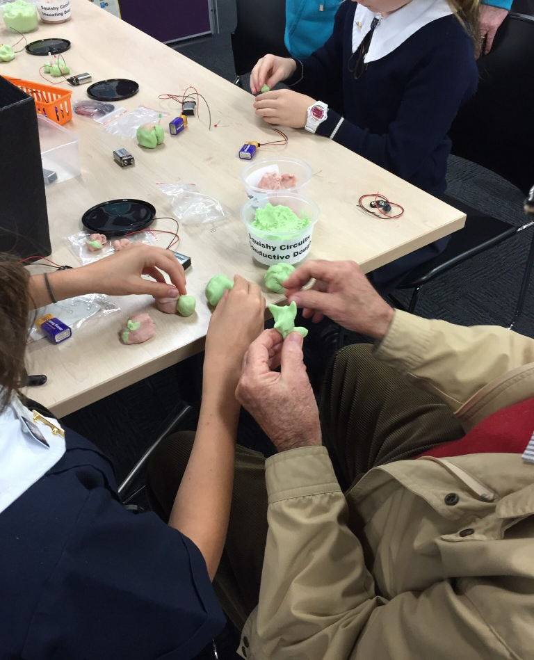Student and grandparent doing experiment with electricity, conduction and playdough