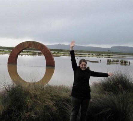 Woman posing in front of a sculpture in a lake.