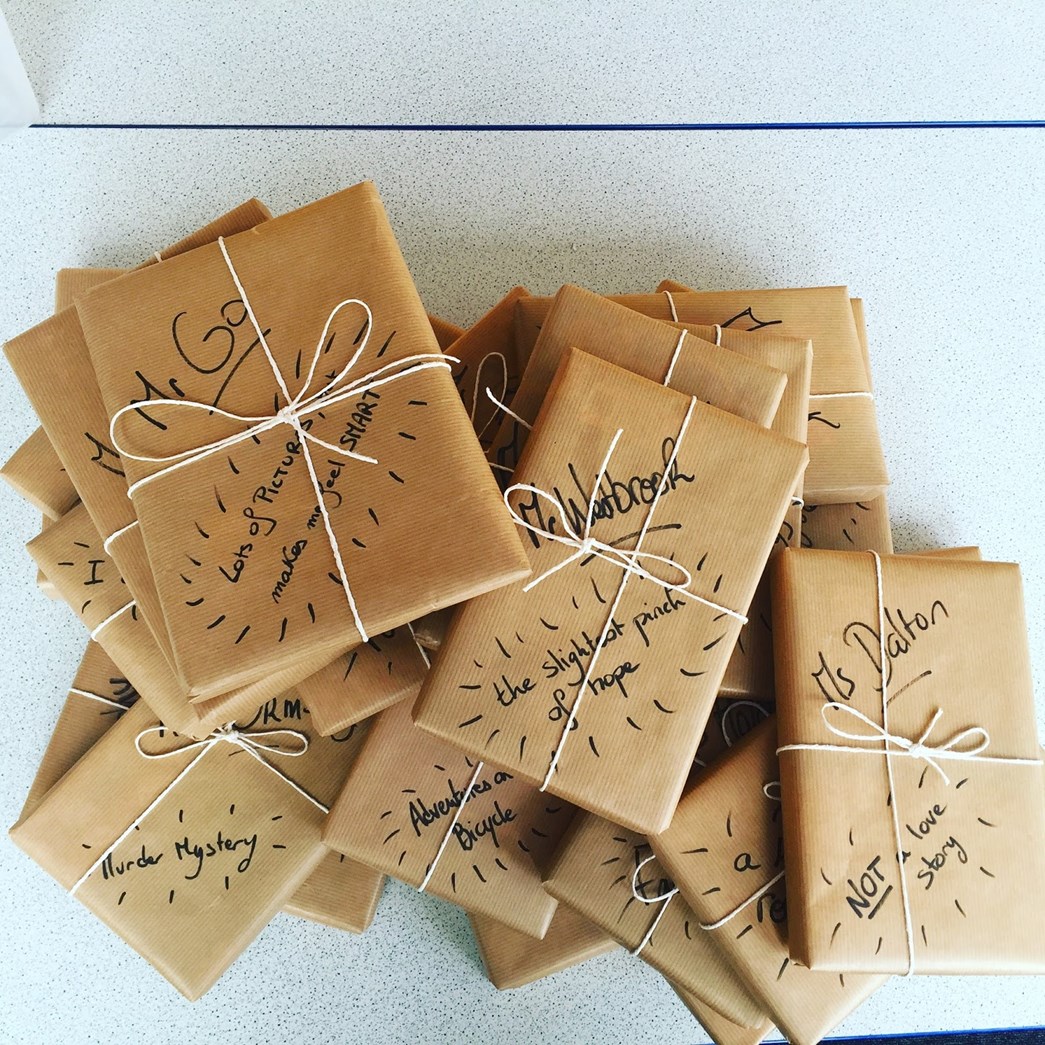 Books wrapped in brown paper to encourage mystery picks.