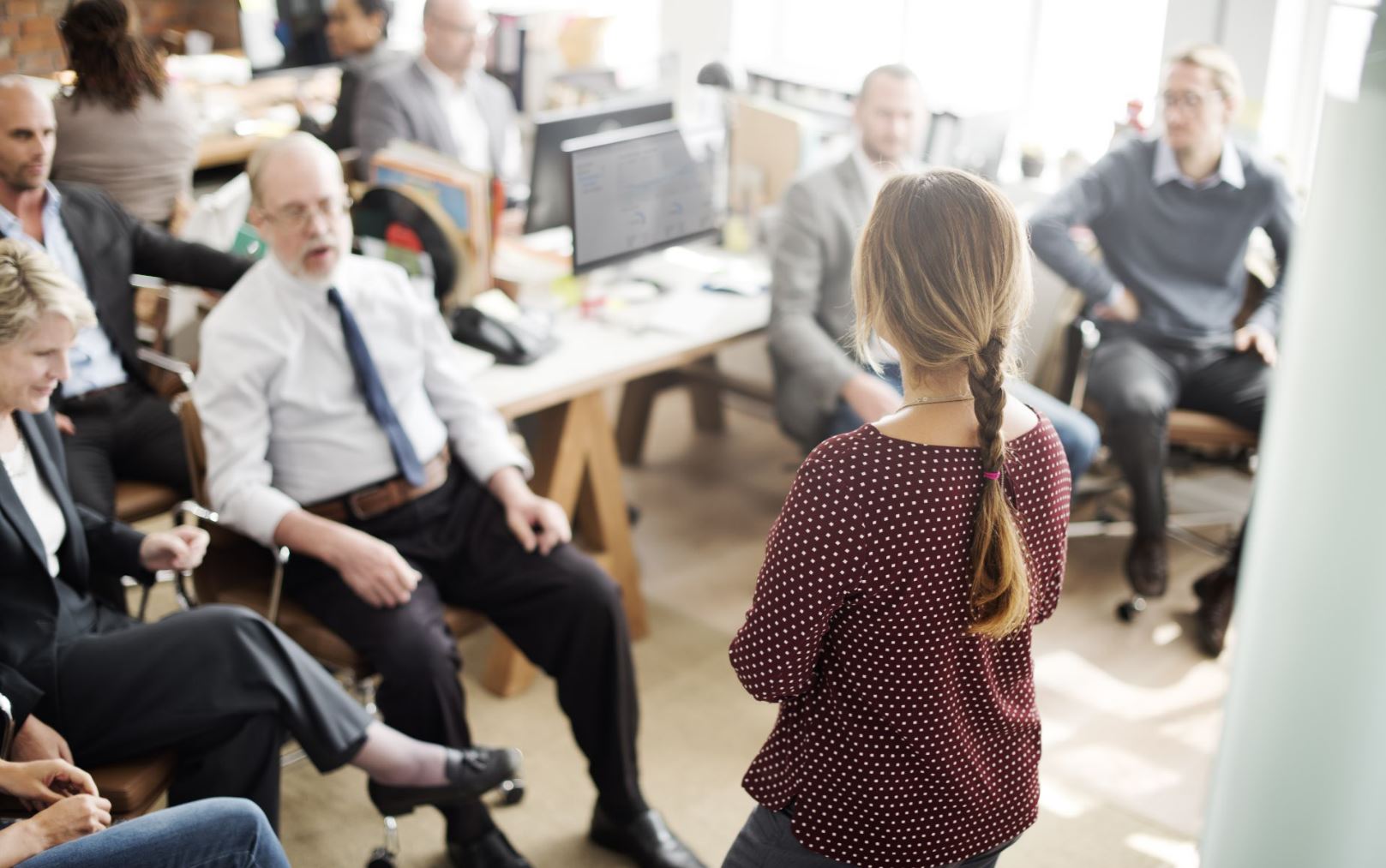 A woman presenting to a room full of colleagues