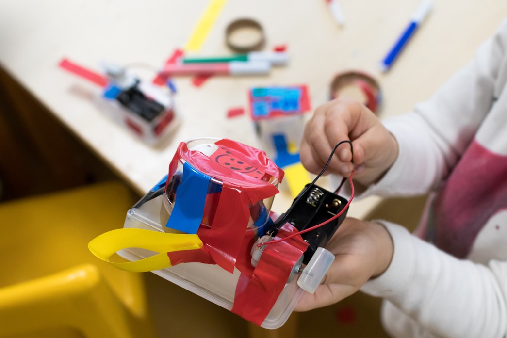 A child holding a homemade circuit board