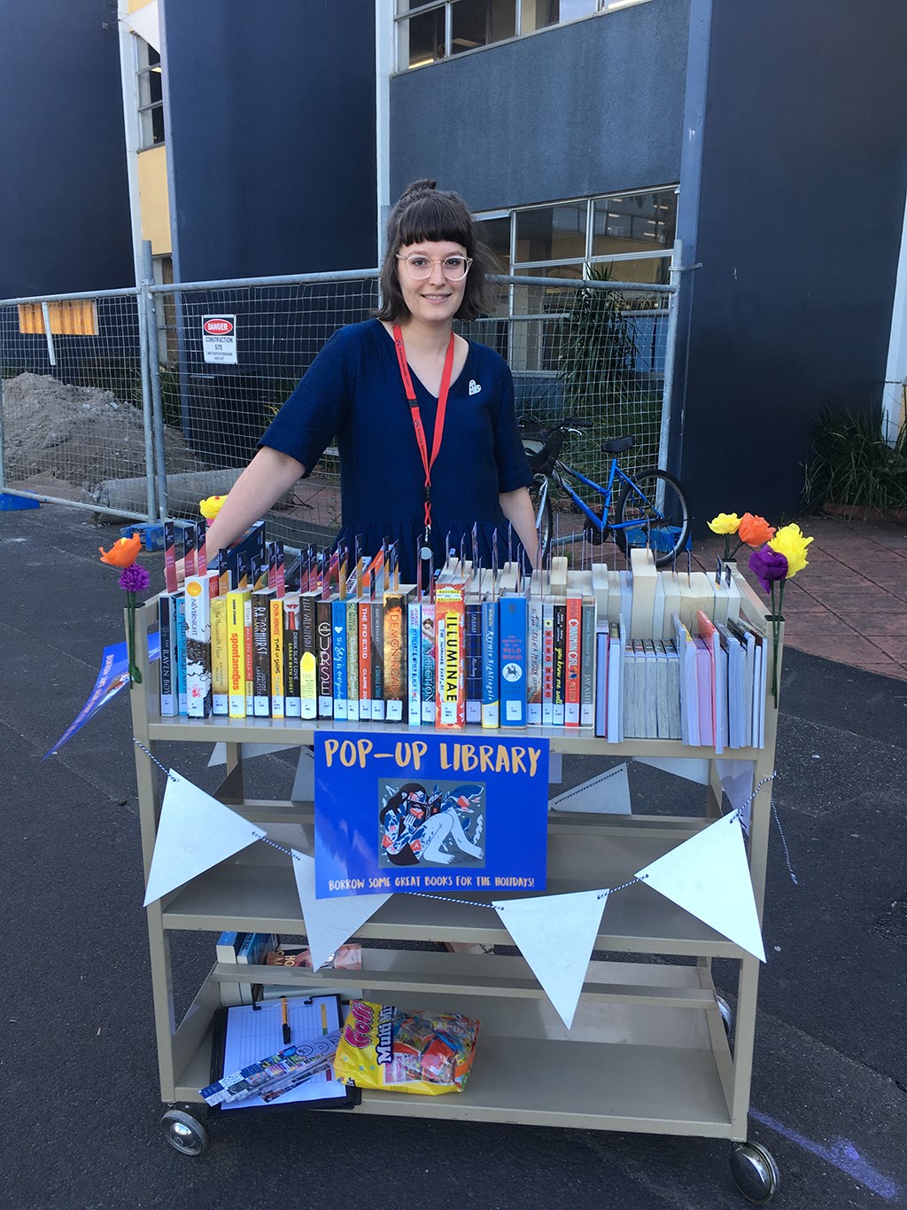 Teacher outside with a pop-up library to encourage reading