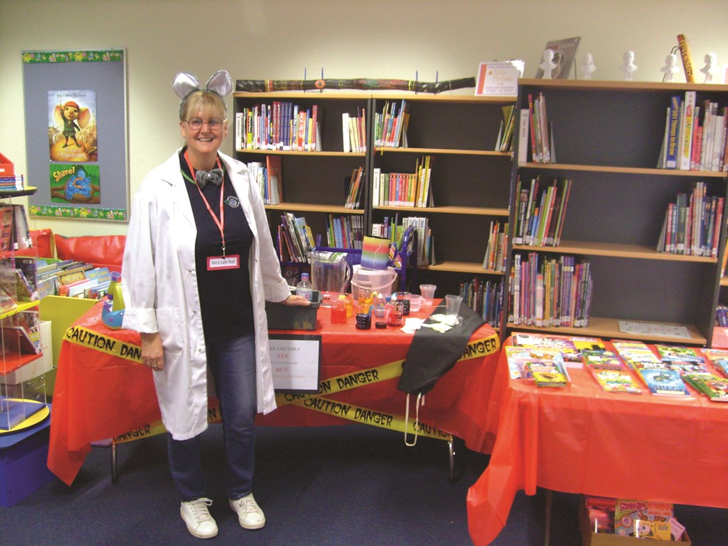 Teacher dressed as Lab Rat during Book Week standing in front of library display