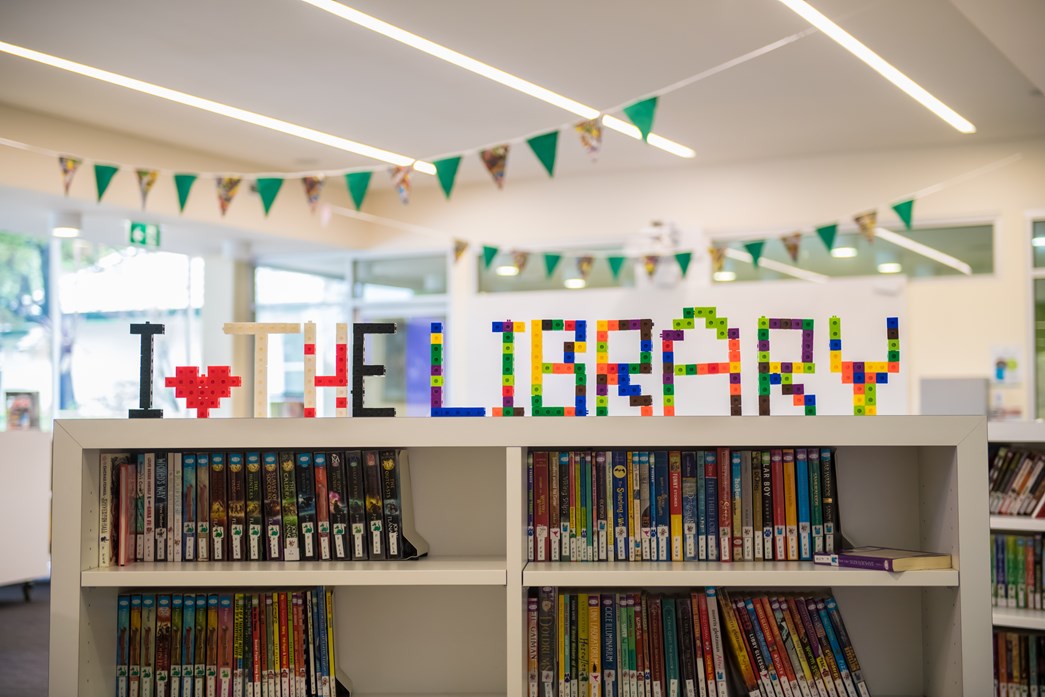 'I Love the Library' display on bookshelf in a library