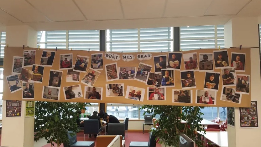 Display of photographs of men reading in a library called 'What Men Read'