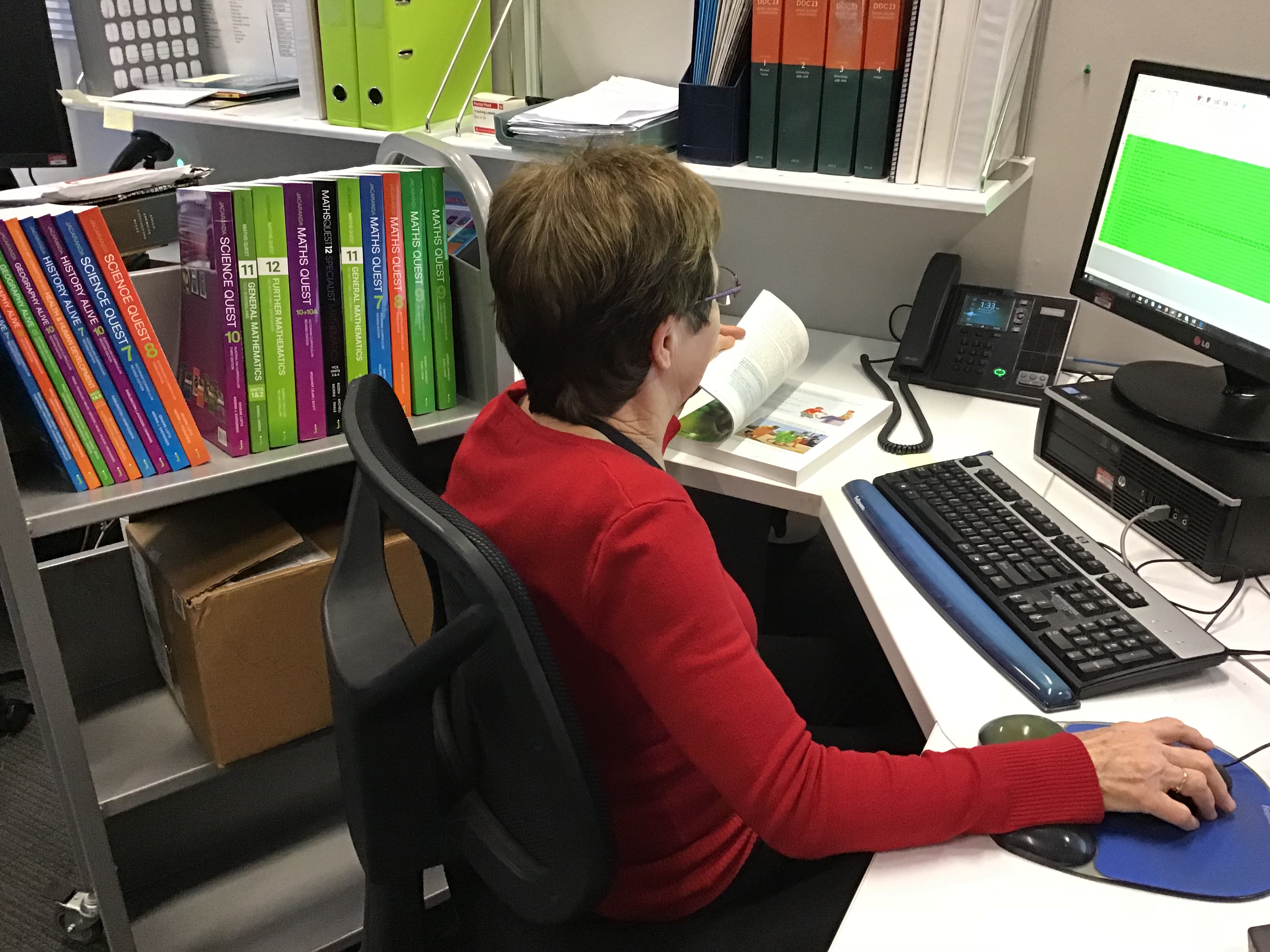 Female librarian cataloging a delivery of books