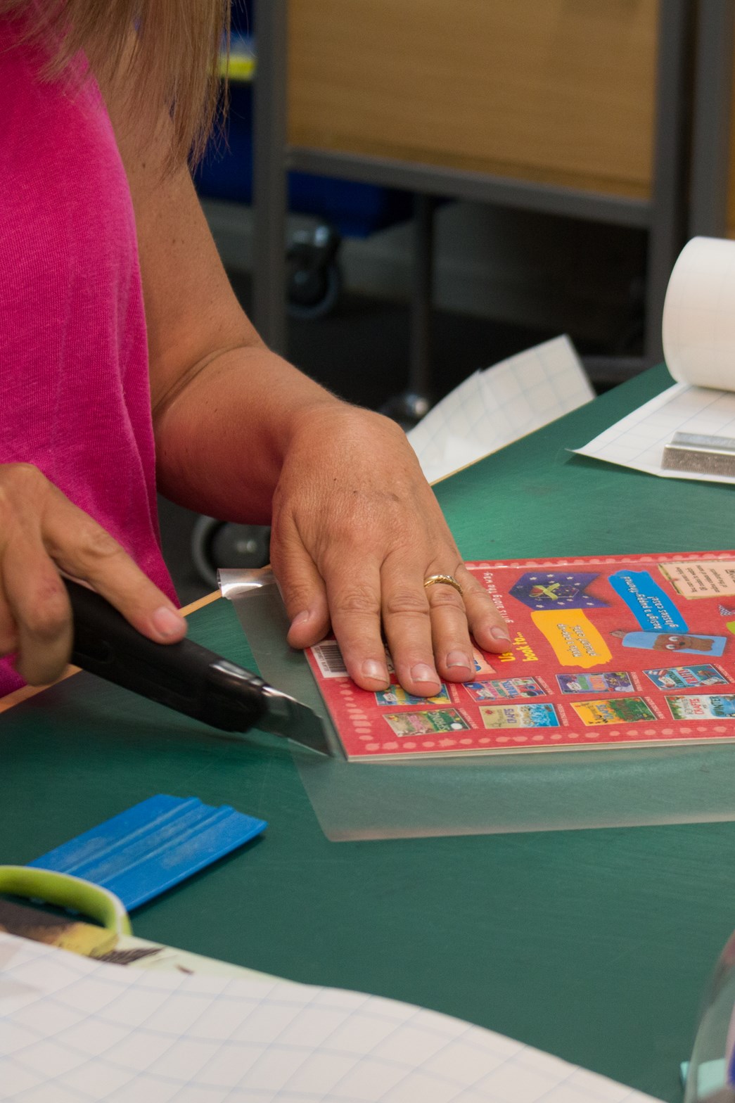 Woman laminating a book with clear contact