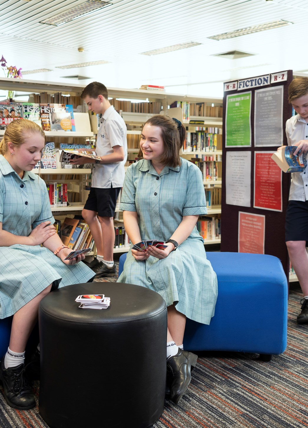 Students playing games and reading on school library