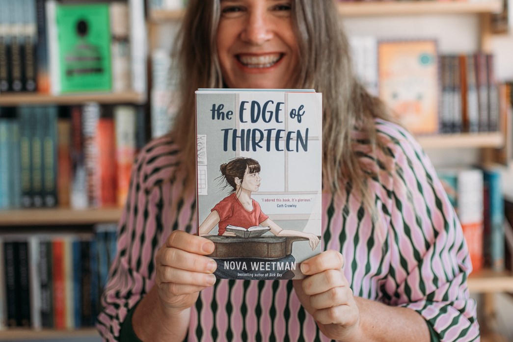 Nova Weetman holding her latest novel,  The Edge of Thirteen, SCIS ID 1999399
