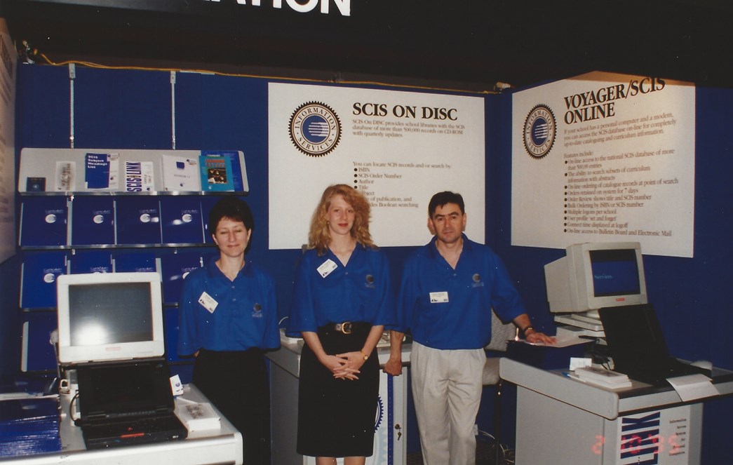 Lance and colleagues posing at a SCIS stand at an expo in the early 1990s