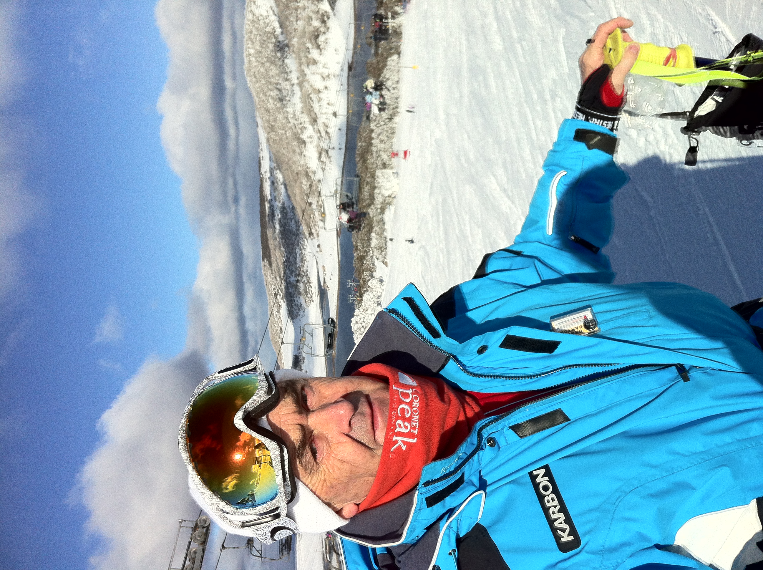 A headshot of Lance Deveson. He is pictured in a ski suit, standing at the top of a snow covered slope