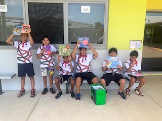 Students from Nemarluk School with books for their library trolley.