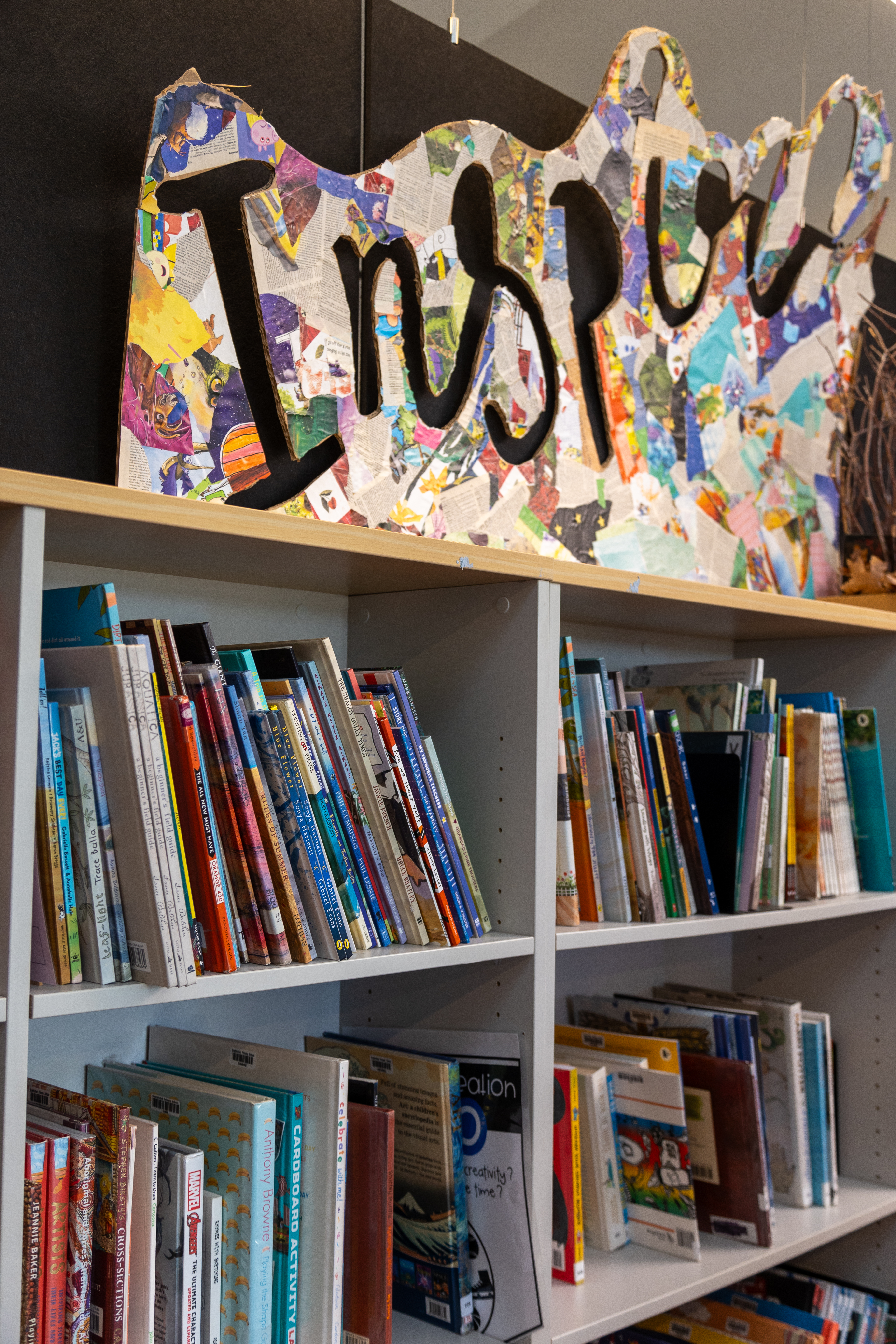 Bookshelves with 'inspire' anove them, carved in to a a collage board