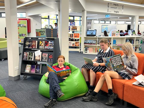 Students sitting in the library reading